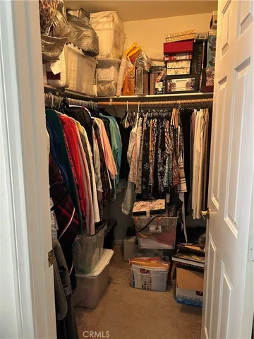a view of walk in closet with clothes and shoes
