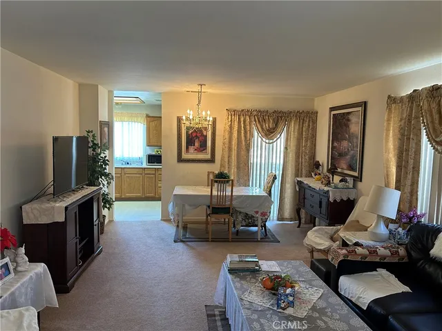 a living room with furniture a flat screen tv and a refrigerator