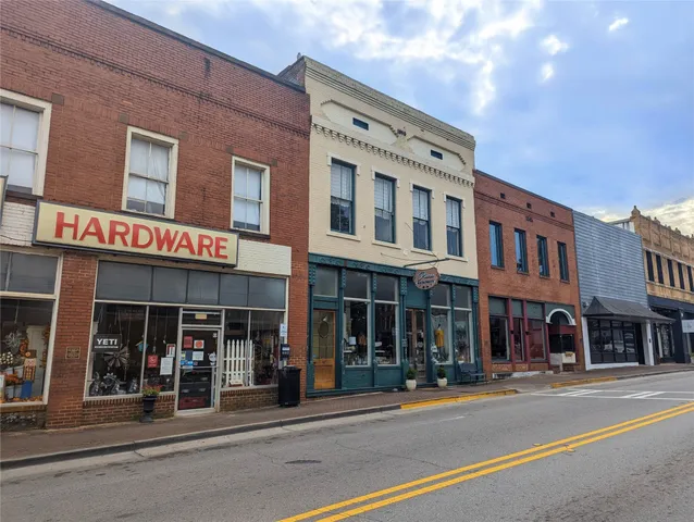 a dining room with wooden floor a chandelier a wooden table and chairs
