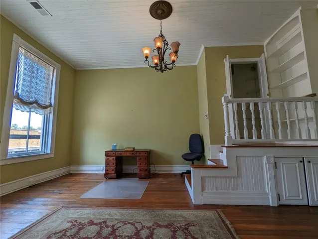 wooden floor fireplace and windows in an empty room