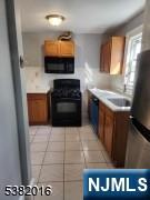 10 Westcott Street Bloomfield, NJ 07003 - Photo 16 of 17 a kitchen with stainless steel appliances kitchen island granite countertop a stove a sink and a microwave