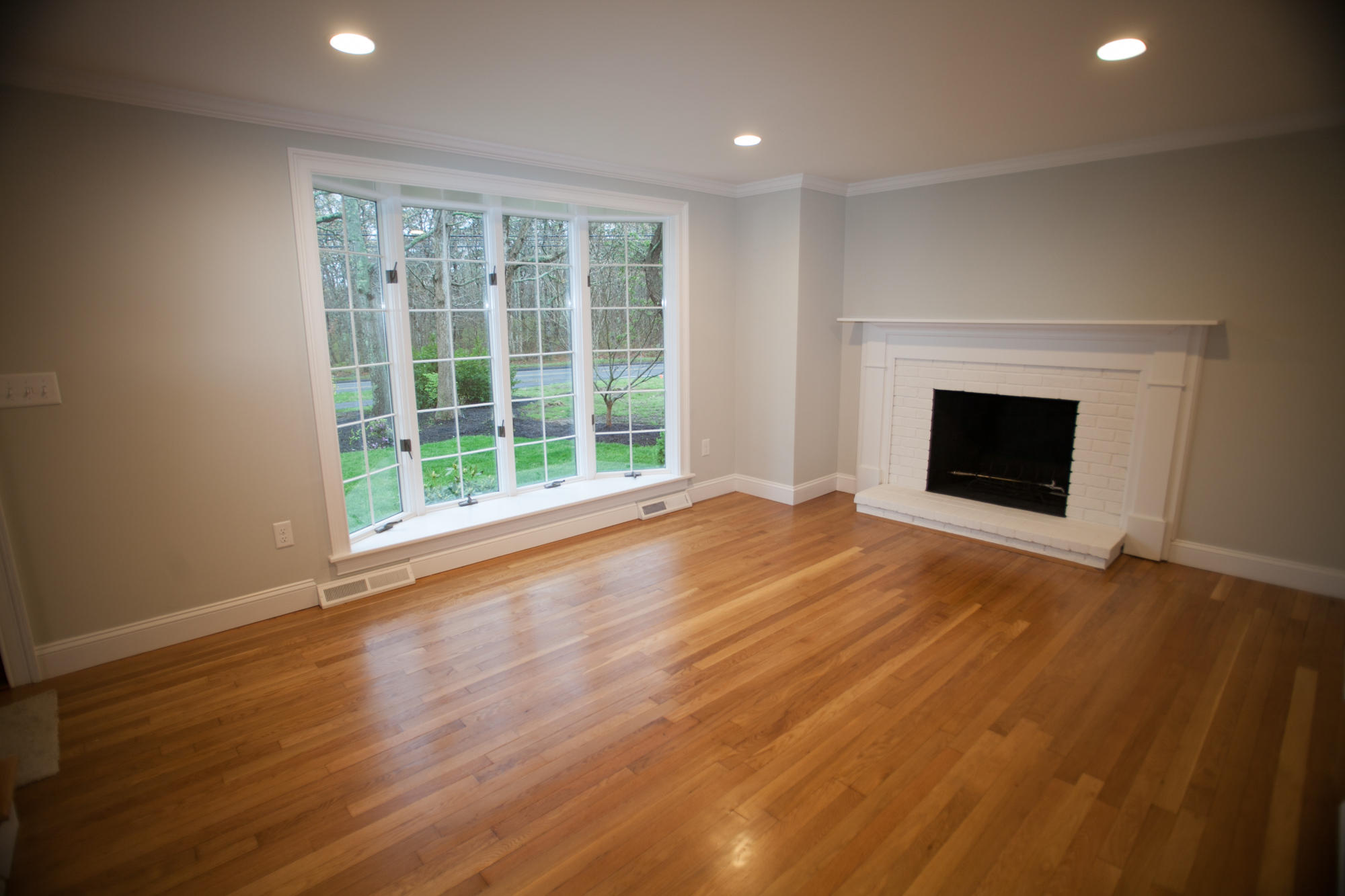 235 Old Craigville Road Hyannis, MA 02601 - Photo 4 of 35 an empty room with wooden floor fireplace and windows