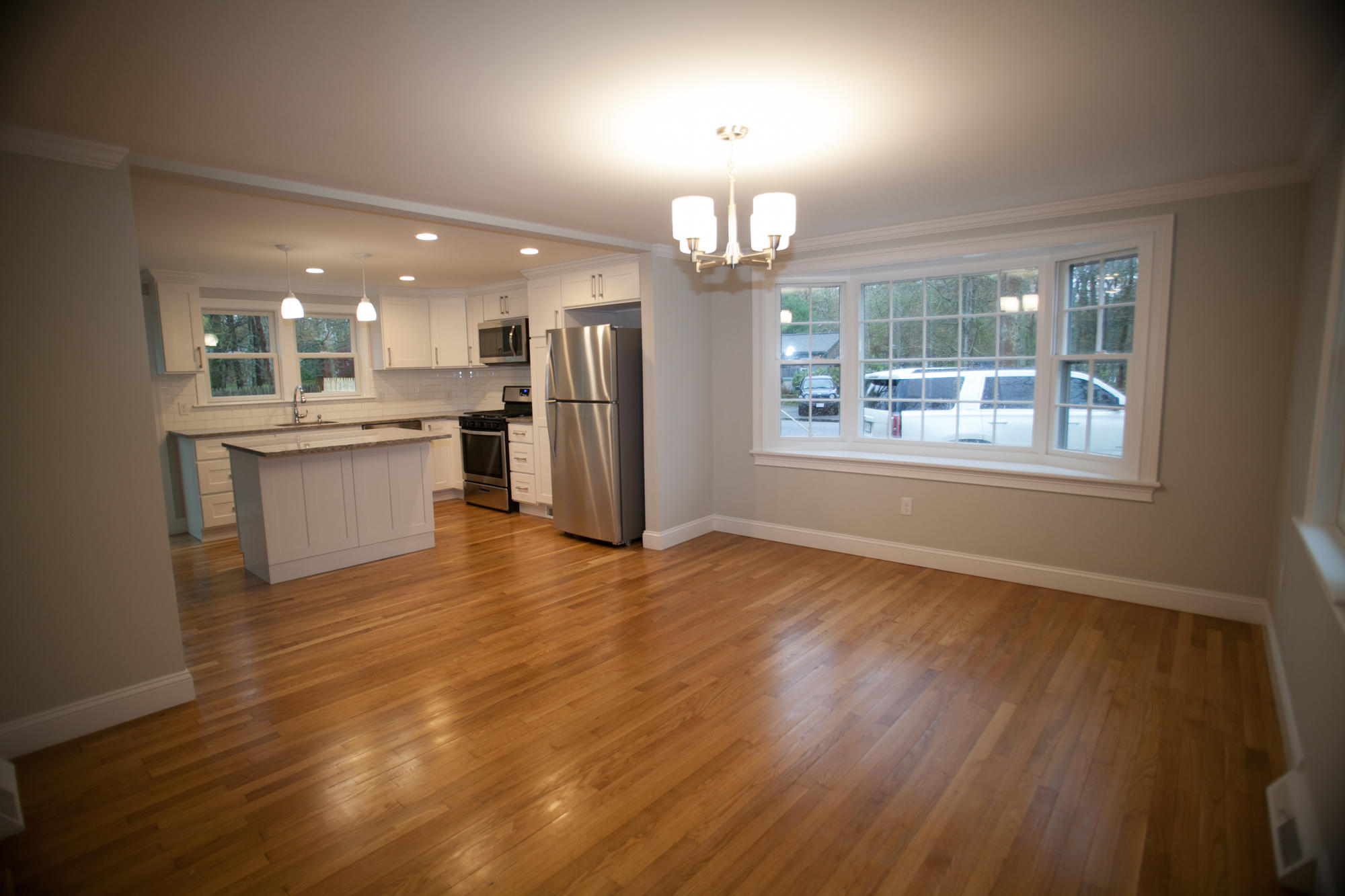 235 Old Craigville Road Hyannis, MA 02601 - Photo 5 of 35 an empty room with wooden floor and kitchen view