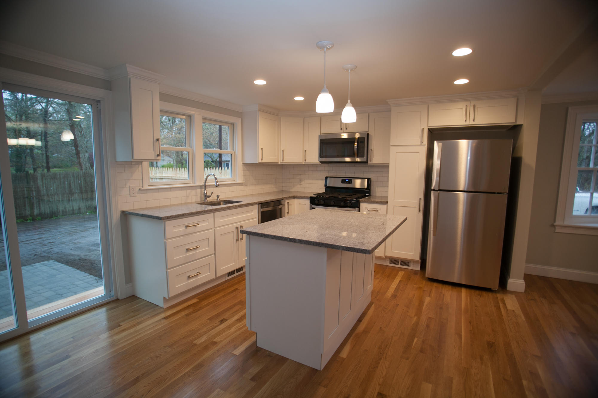 235 Old Craigville Road Hyannis, MA 02601 - Photo 8 of 35 a kitchen with a sink a refrigerator a microwave oven and cabinets with wooden floor