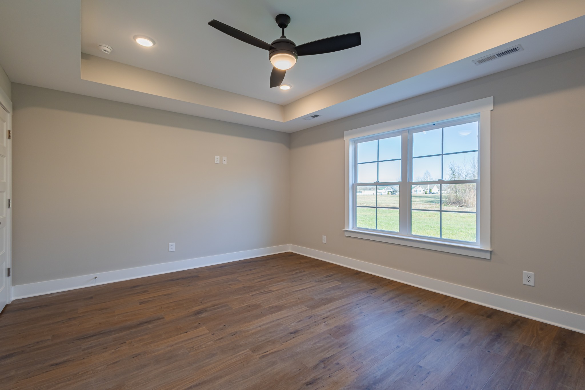 71 Brooklyn Avenue Manchester, TN 37355 - Photo 37 of 69 an empty room with wooden floor ceiling fan and windows