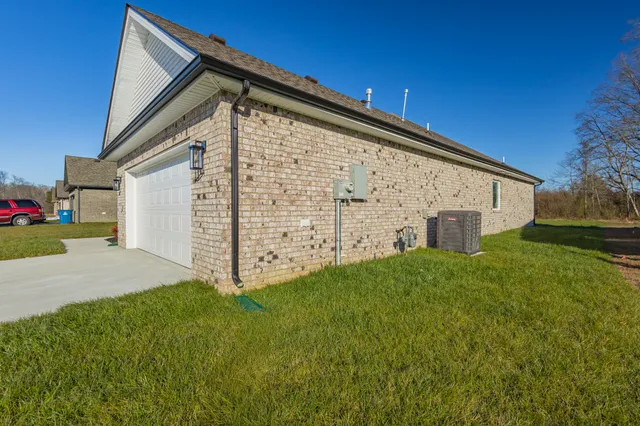 an empty room with wooden floor ceiling fan and windows