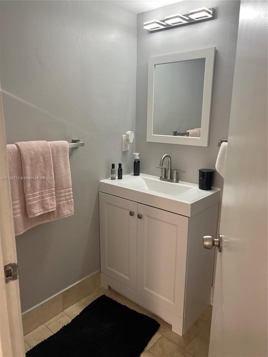 13983 Southwest 46th Terrace, Unit C Miami, FL 33175 - Photo 3 of 8 a bathroom with a toilet sink and mirror