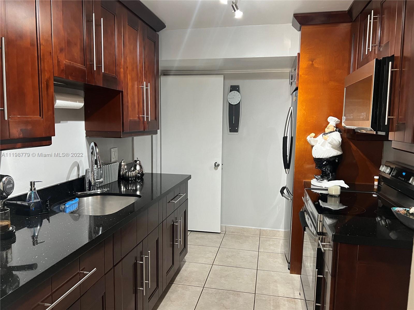 13983 Southwest 46th Terrace, Unit C Miami, FL 33175 - Photo 5 of 8 a kitchen with a sink and a stove