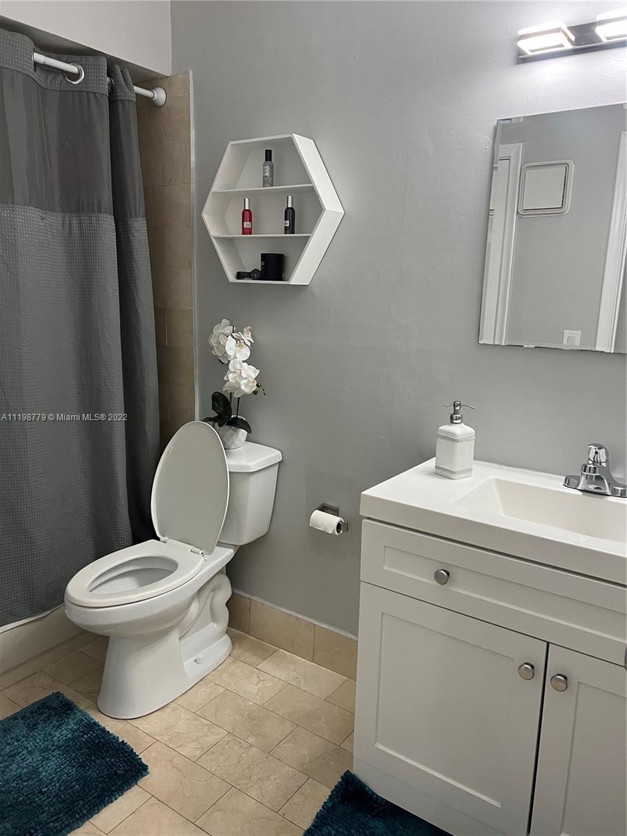 13983 Southwest 46th Terrace, Unit C Miami, FL 33175 - Photo 8 of 8 a bathroom with a toilet sink vanity and mirror