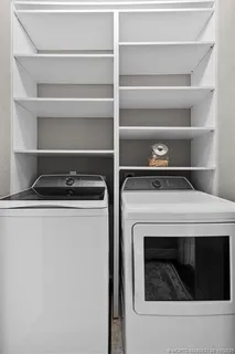 a backyard of a house with plants and large tree