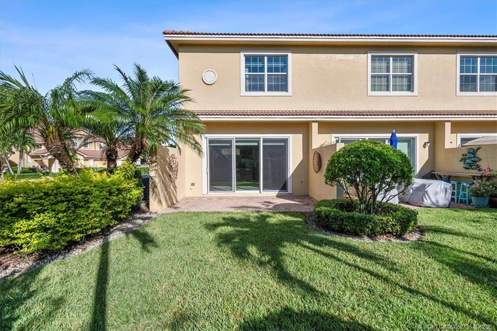 692 Southwest Glen Crest Way Stuart, FL 34997 - Photo 22 of 38 a front view of a house with a yard and potted plants