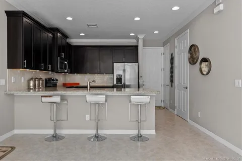 a kitchen with white cabinets and sink