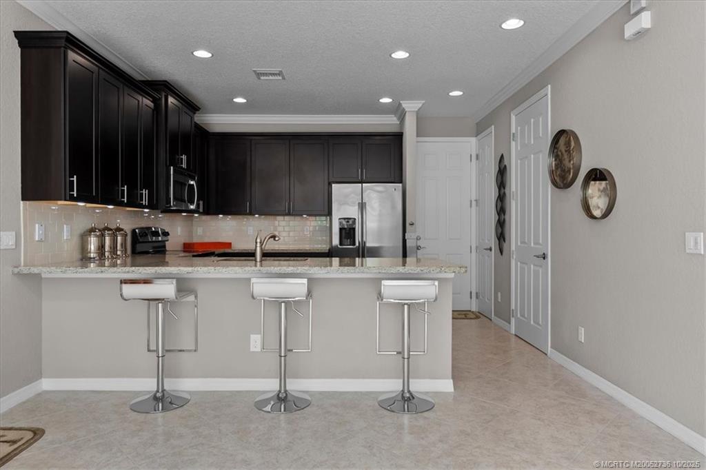 692 Southwest Glen Crest Way Stuart, FL 34997 - Photo 4 of 38 a kitchen with white cabinets and sink