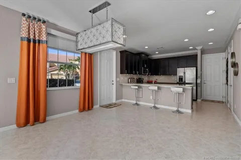 a view of kitchen with stainless steel appliances granite countertop a refrigerator and a stove top oven