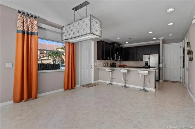 a view of kitchen with stainless steel appliances granite countertop a refrigerator and a stove top oven