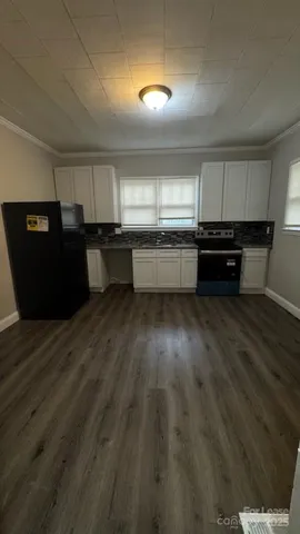 a kitchen with kitchen island granite countertop a refrigerator and a stove