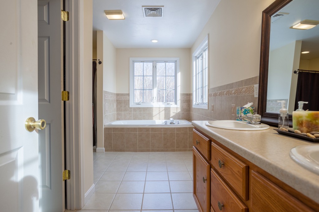 152 Old Worcester Road Charlton, MA 01507 - Photo 16 of 28 a spacious bathroom with a tub sink and mirror