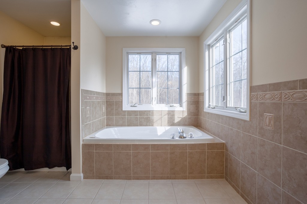 152 Old Worcester Road Charlton, MA 01507 - Photo 17 of 28 a bath tub sitting in a bathroom next to a window
