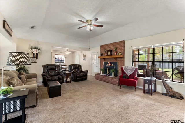 a living room with furniture fireplace and large window