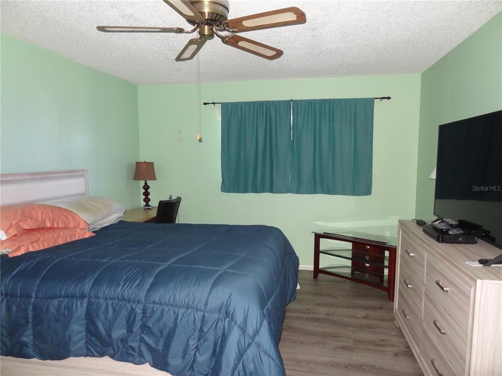 11135 Carriage Hill Drive, Unit 3 Port Richey, FL 34668 - Photo 16 of 25 a bedroom with a bed and a flat screen tv