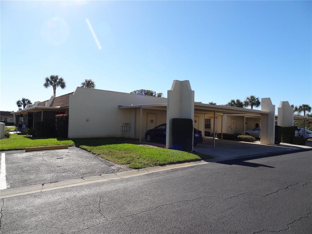 11135 Carriage Hill Drive, Unit 3 Port Richey, FL 34668 - Photo 22 of 25 a view of a house with a yard and a road