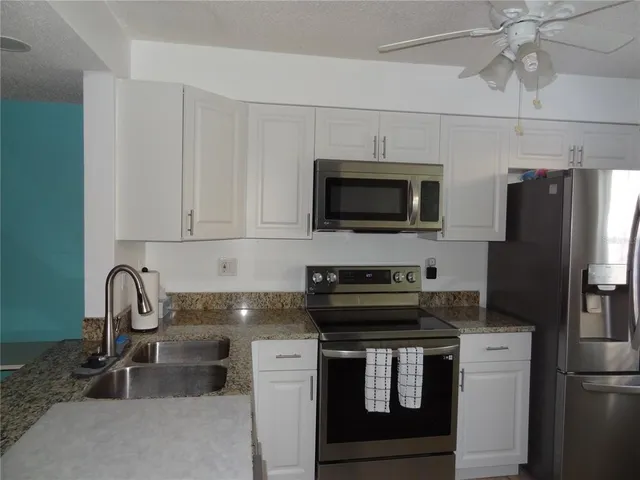 a kitchen with a sink appliances and cabinets