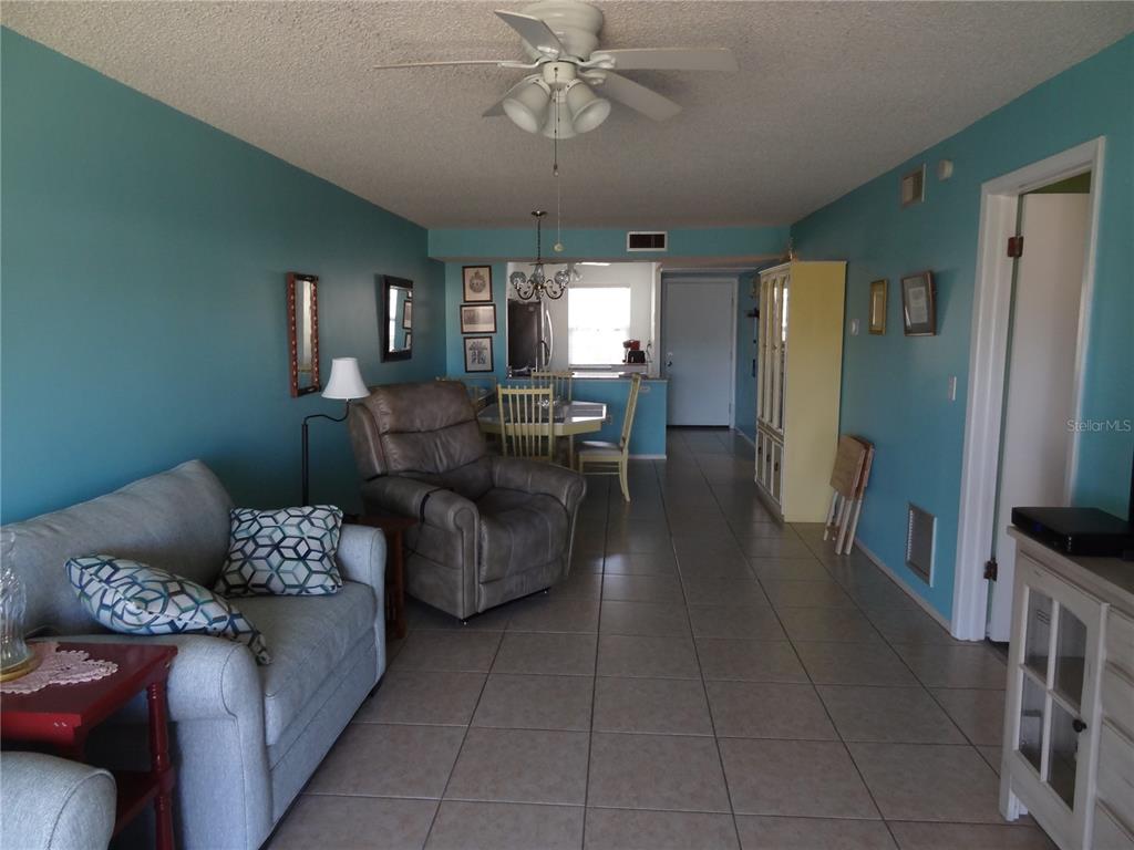 11135 Carriage Hill Drive, Unit 3 Port Richey, FL 34668 - Photo 10 of 25 a living room with furniture and a chandelier