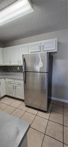 a kitchen with stainless steel appliances granite countertop a refrigerator and a stove