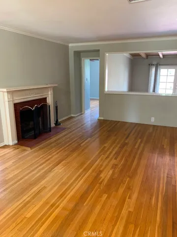 an empty room with wooden floor and a fireplace