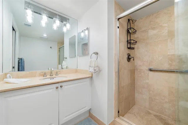 a bathroom with a double vanity sink mirror and shower
