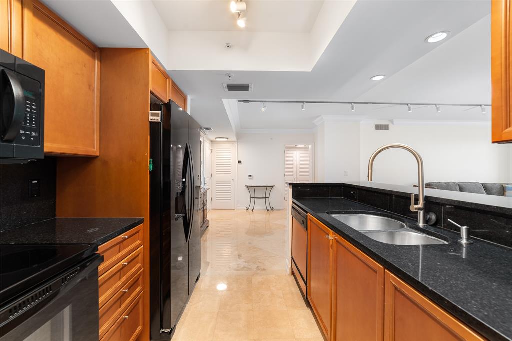 99 Southeast Mizner Boulevard, Unit 603 Boca Raton, FL 33432 - Photo 24 of 34 a kitchen with granite countertop a sink and cabinets
