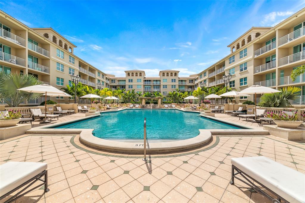 99 Southeast Mizner Boulevard, Unit 603 Boca Raton, FL 33432 - Photo 3 of 34 a view of a swimming pool with a lounge chairs