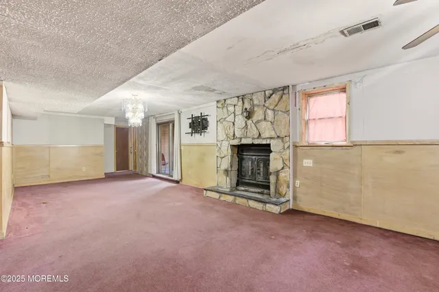 an empty room with fireplace and windows