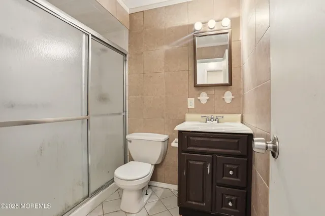 a bathroom with a granite countertop toilet sink and mirror