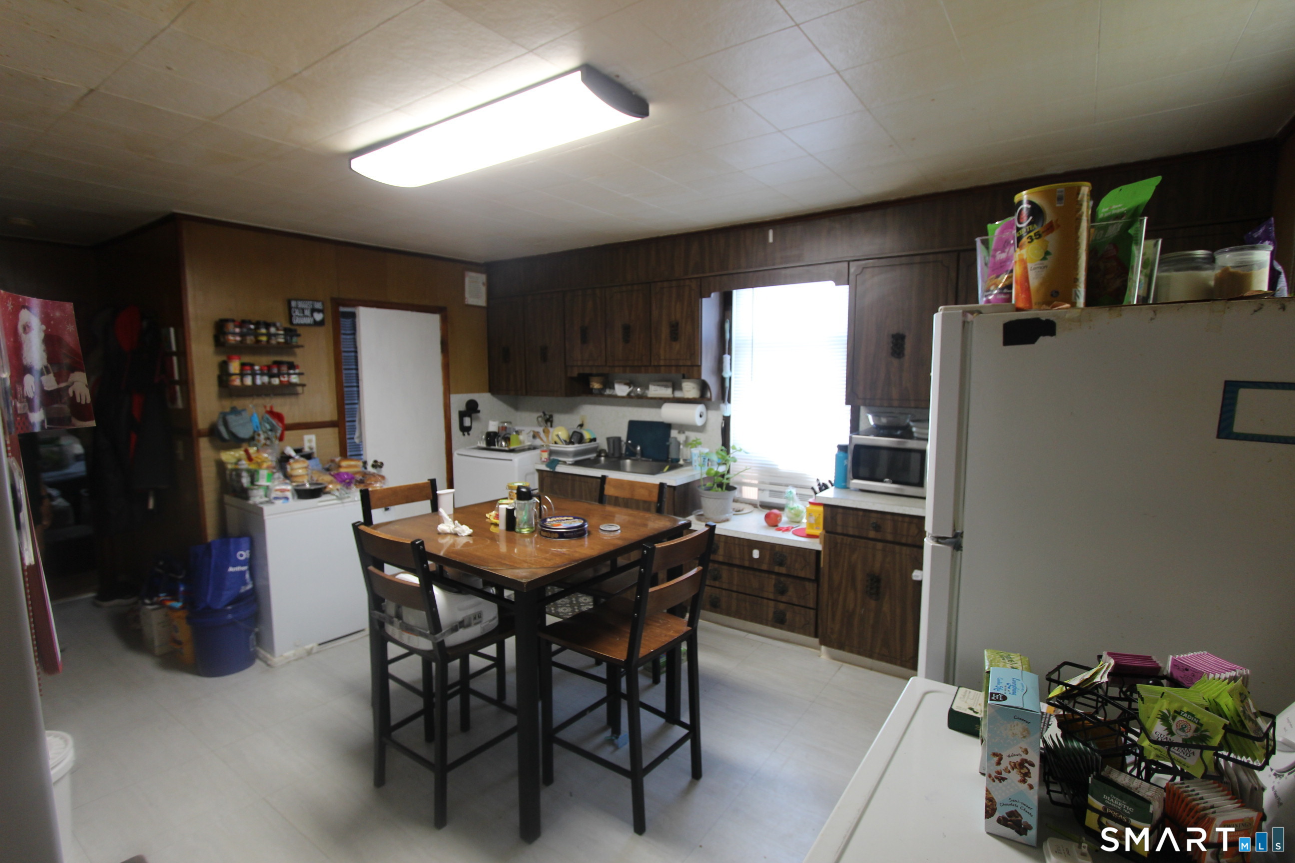 23 North Spring Street Ansonia, CT 06401 - Photo 5 of 7 a kitchen with a table chairs refrigerator and microwave