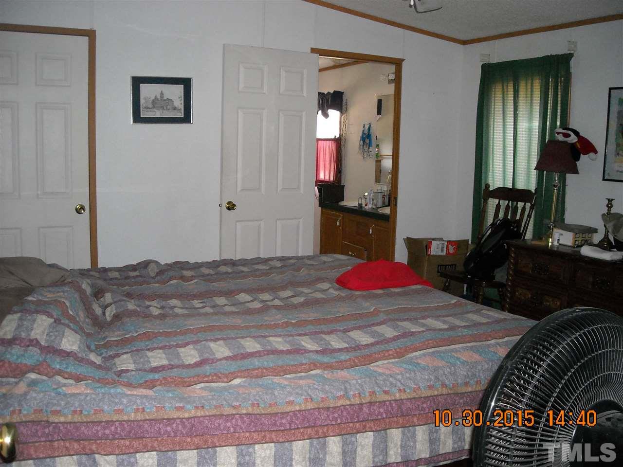 2572 Courtney Road Oxford, NC 27565 - Photo 22 of 25 a bedroom with a bed and a chandelier