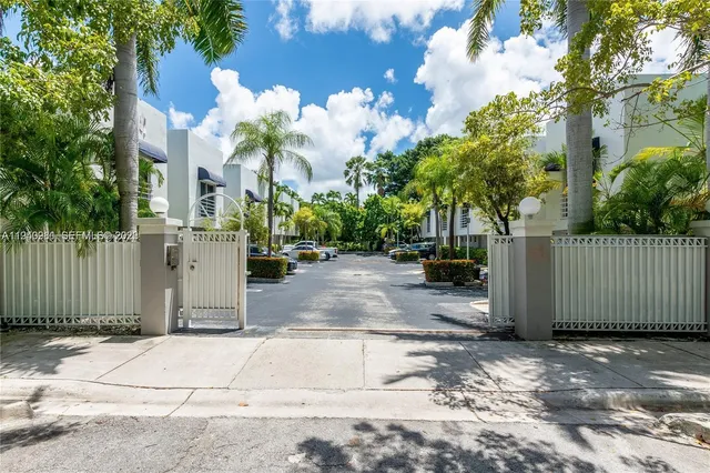 a view of a brick house with a large trees and flower plants in front of main door
