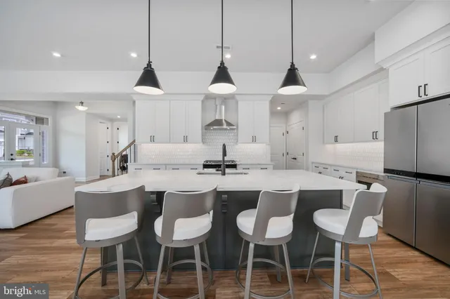 a kitchen with stainless steel appliances a dining table chairs and wooden floor