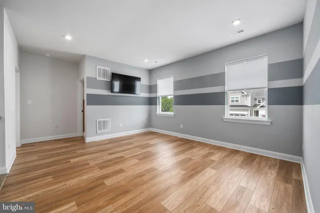 a view of empty room with wooden floor and fireplace