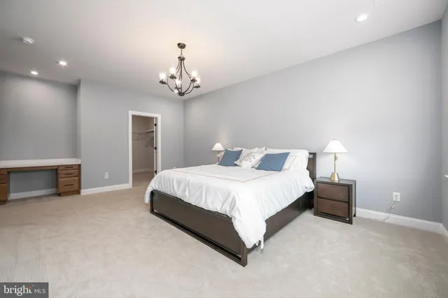 a spacious bedroom with a bed and a chandelier