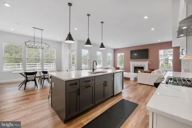 a large kitchen with kitchen island granite countertop a stove a sink a island and chairs