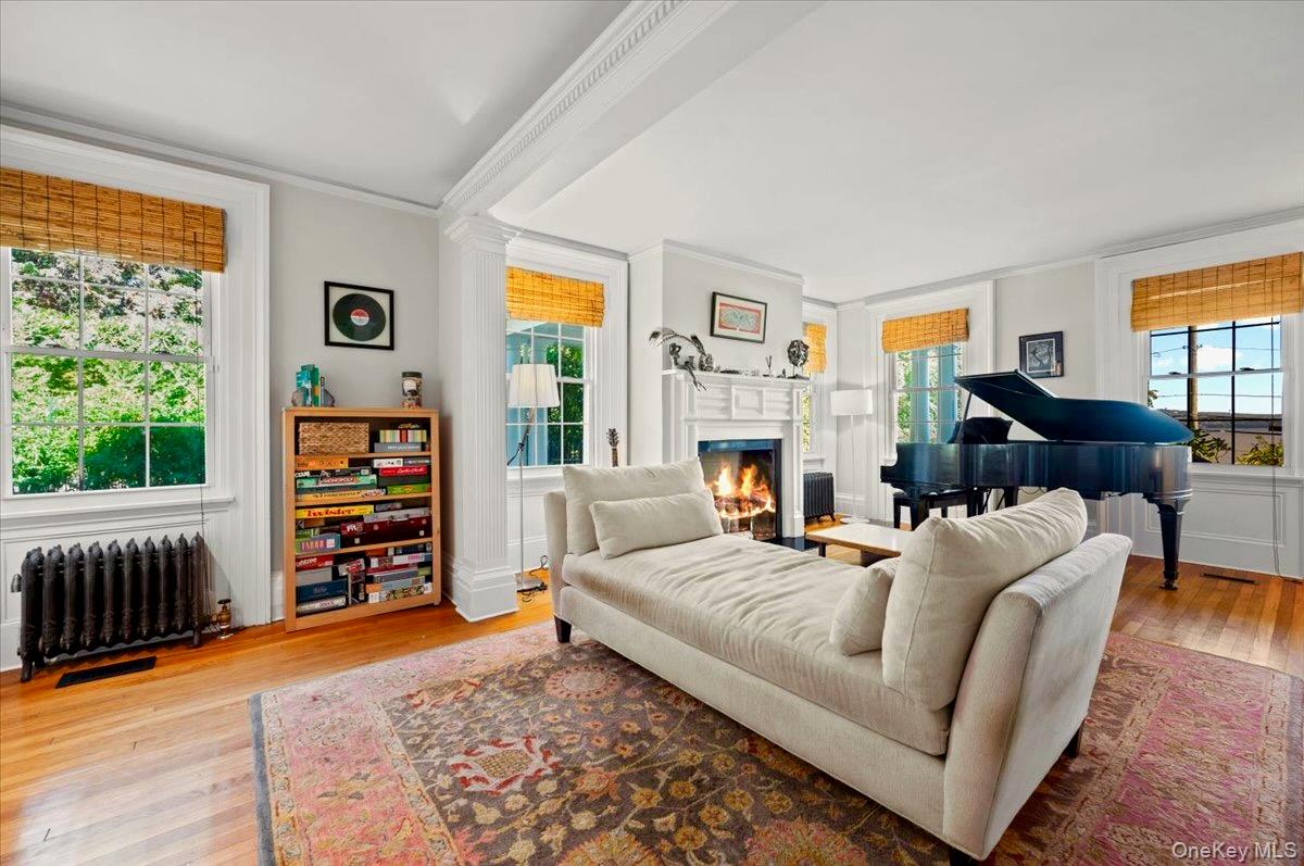245 River Road Nyack, NY 10960 - Photo 12 of 45 Living room featuring radiator heating unit, healthy amount of natural light, light wood-type flooring, fireplace, and ornamental molding