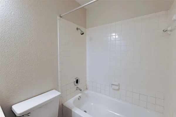 a white bath tub sitting next to a white toilet and a sink