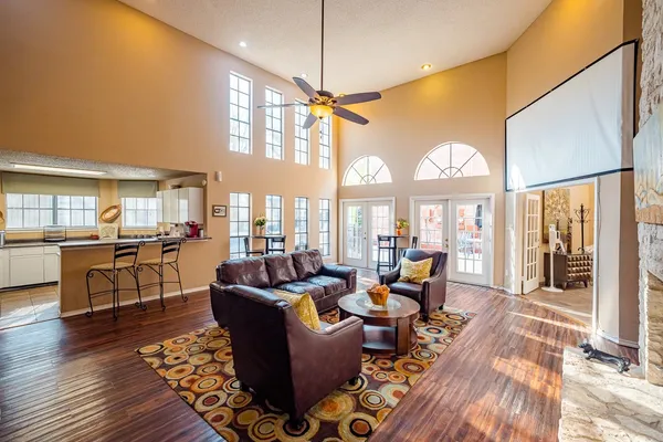 a living room with furniture large window and wooden floor