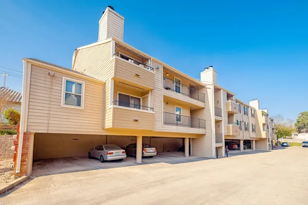 a front view of a building with cars parked