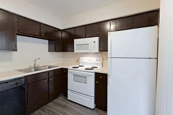 a kitchen with a sink a refrigerator and cabinets