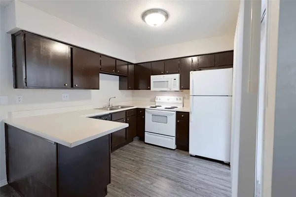 a kitchen with a sink a refrigerator a oven and white cabinets