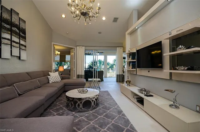 a living room with furniture a flat screen tv and kitchen view