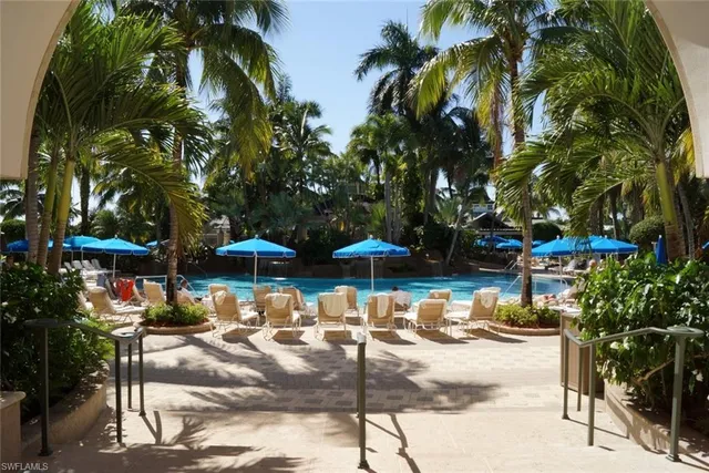 a view of patio with chairs and table under an umbrella