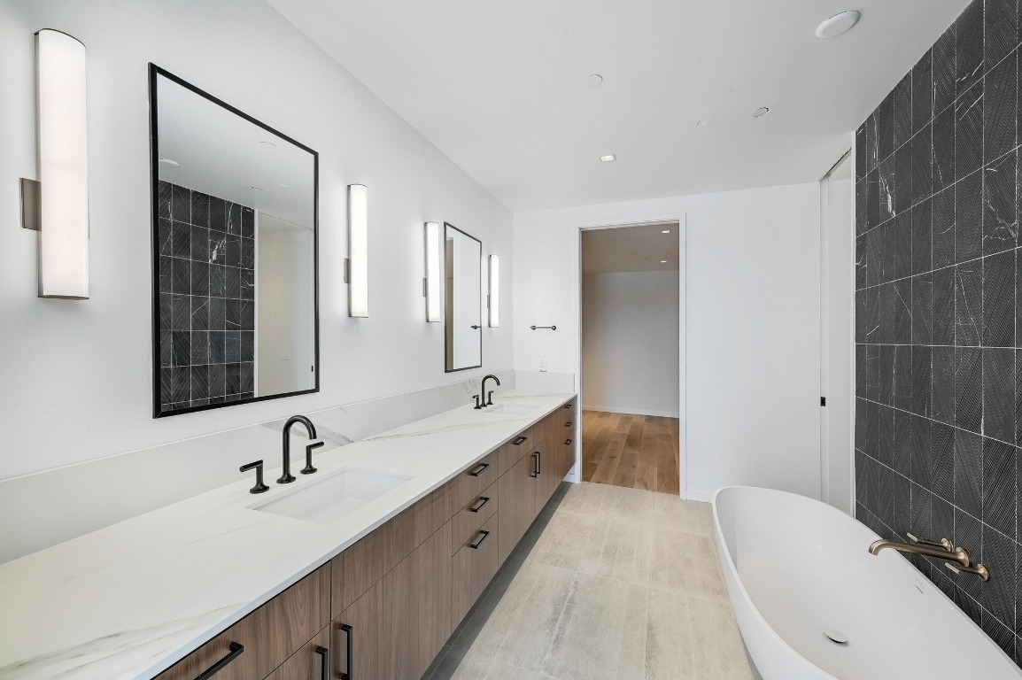 1006 Baylor Street, Unit 202 Austin, TX 78703 - Photo 10 of 23 a bathroom with a double vanity sink a mirror and a bathtub